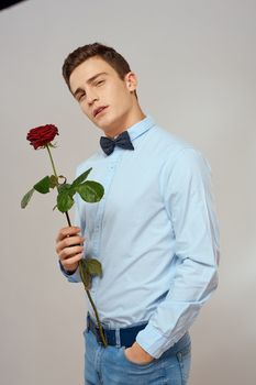 romantic man with red rose and light shirt pants suit. High quality photo