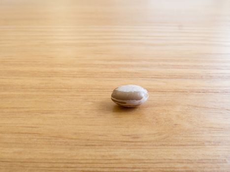 A grain of carioca beans isolated, on wooden texture table.