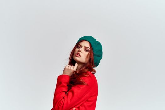 Woman in red coat and in green hat on isolated background cropped model with Copy Space emotions. High quality photo