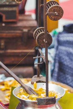 Weaver digests cocoons of silkworm butterflies and spins one thread from them. Manual production of silk fabric using old traditional devices. Bangkok, Thailand.