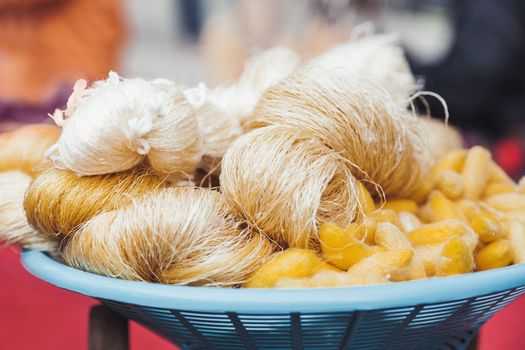 Cocoons of silkworm butterflies and threads made from them. Manual production of silk. Bangkok, Thailand.