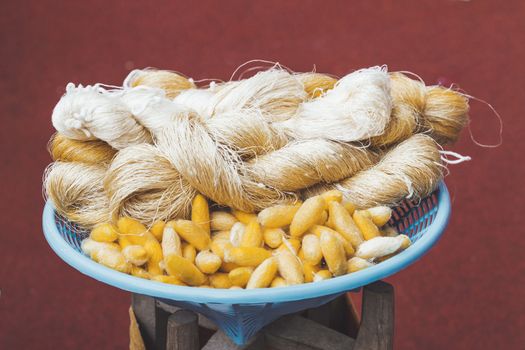 Cocoons of silkworm butterflies and threads made from them. Manual production of silk. Bangkok, Thailand.