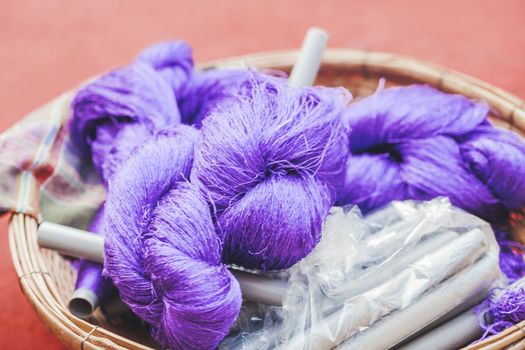 Coils of violet coloured silk thread. Natural product silkworm butterflies cocoons. Manual production of silk fabric. Bangkok, Thailand.