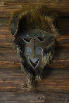 An animal skin mask hangs on the wall