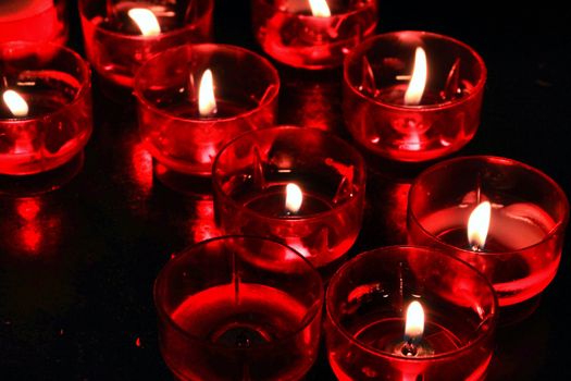 Texture of red candles lit by prayers in a church of Lisbon