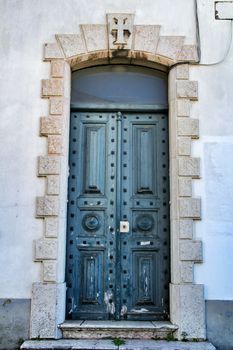 Old and colorful green wooden door with iron details in Lisbon, Portugal
