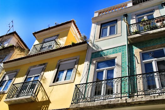 Old colorful and majestic tiled facades with vintage streetlight in Lisbon streets in Spring.