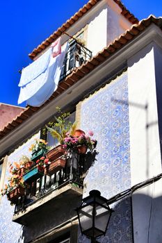 Old facade of typical Lisbon house with hanging clothes in clothesline.