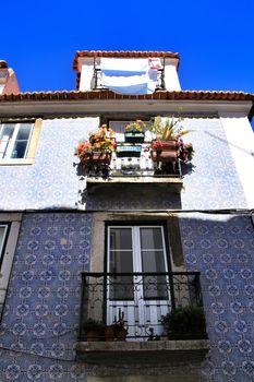 Old facade of typical Lisbon house with hanging clothes in clothesline.