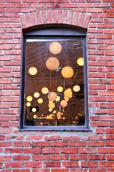 Round white lamps seen through a window. 