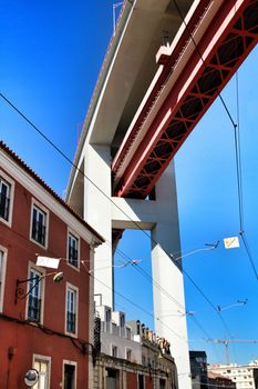 Beautiful 25th April bridge structure over street in Lisbon in a sunny day of Spring