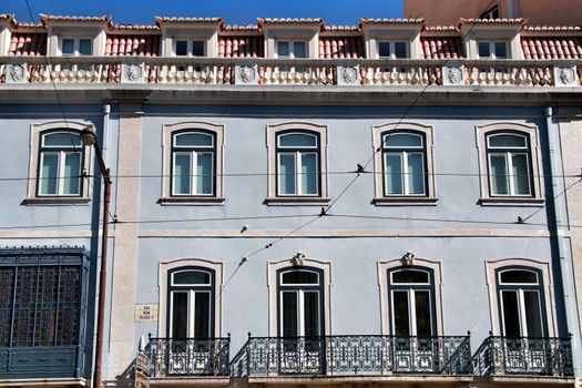 Old colorful and majestic tiled facades with vintage streetlight in Lisbon streets in Spring.