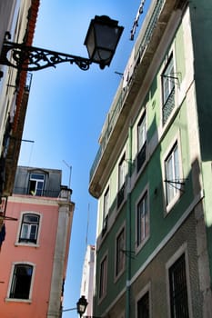 Old colorful and majestic tiled facades with vintage streetlight in Lisbon streets in Spring.