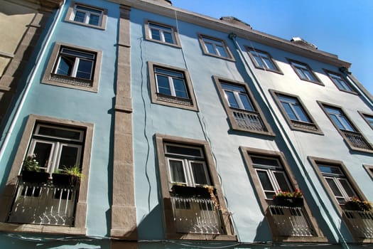 Old colorful and majestic tiled facades with vintage streetlight in Lisbon streets in Spring.