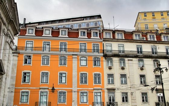 Old colorful and beautiful facades with vintage streetlight in Lisbon streets in Spring. Clothesline in the facade with hanging clothes