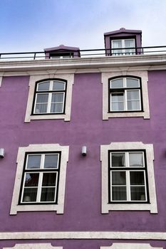 Old colorful and beautiful facades with vintage streetlight in Lisbon streets in Spring. Clothesline in the facade with hanging clothes
