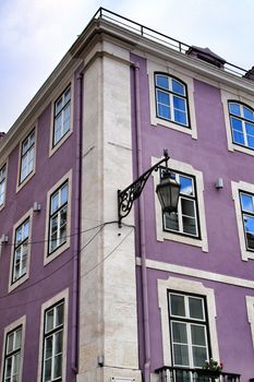 Old colorful and beautiful facades with vintage streetlight in Lisbon streets in Spring. Clothesline in the facade with hanging clothes