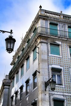 Old colorful and beautiful facades with vintage streetlight in Lisbon streets in Spring. Clothesline in the facade with hanging clothes