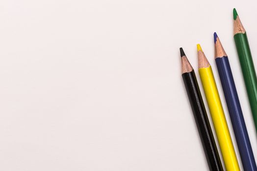 Colour pencils lay on white background, school design