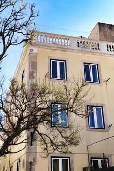 Old colorful and beautiful facades with vintage streetlight in Lisbon streets in Spring. Clothesline in the facade with hanging clothes
