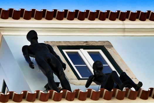 Colorful facade with two black mannequins in Lisbon in a sunny day of spring