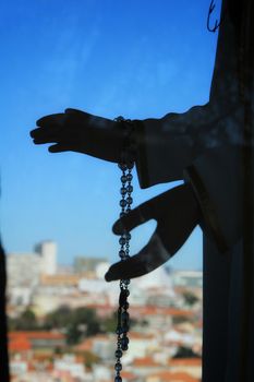 Image of the Virgin Mary hands holding a rosary in Nossa Senhora Do Monte viewpoint in Lisbon in a sunny day of winter