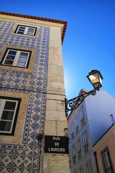 Old colorful and beautiful facades with vintage streetlight in Lisbon streets in Spring. 