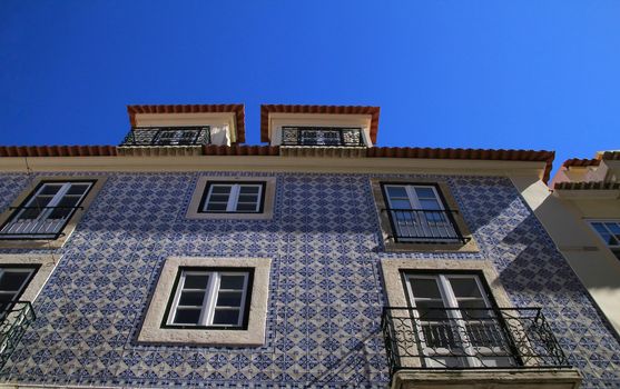 Old colorful and beautiful facades with vintage streetlight in Lisbon streets in Spring. 
