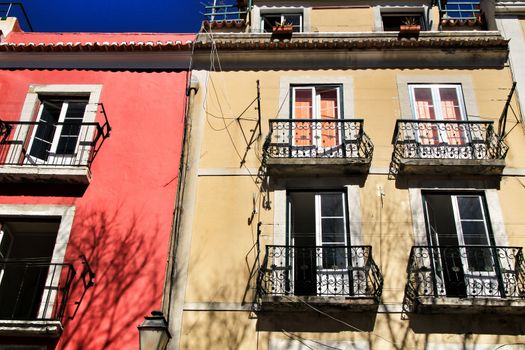 Old colorful and beautiful facades with vintage streetlight in Lisbon streets in Spring. Clothesline in the facade with hanging clothes
