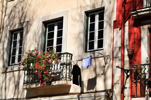 Old colorful and beautiful facades with vintage streetlight in Lisbon streets in Spring. Clothesline in the facade with hanging clothes