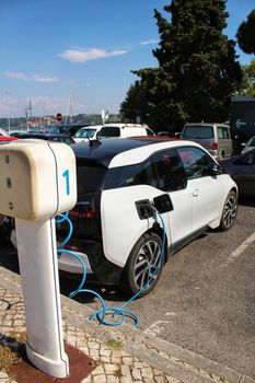 Electric car parked and charging on the banks of the river Tagus in Lisbon