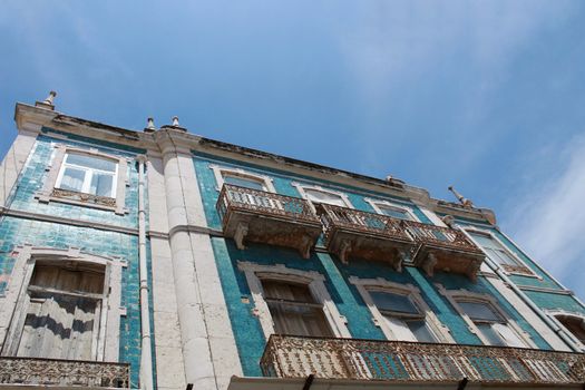 Old colorful and tiled facades with vintage streetlight in Lisbon streets in Spring. Clothesline in the facade with hanging clothes