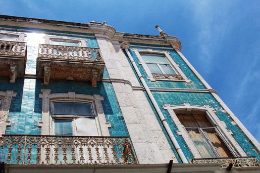 Old colorful and tiled facades with vintage streetlight in Lisbon streets in Spring. Clothesline in the facade with hanging clothes