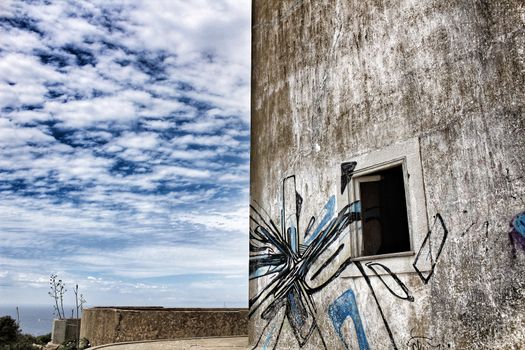 Old abandoned house in Cape Espiche, Portugal. Blue and cloudy sky.