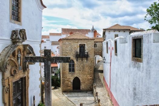 Narrow and colorful streets, majestic facades, windows and balconies of the old village of Obidos, Portugal