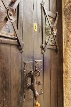 Old wooden door in Lisbon. Wrought metal details on the door.