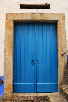 Old wooden door in Lisbon. Wrought metal details on the door.