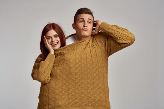 couple in yellow sweater posing against light background cropped view. High quality photo