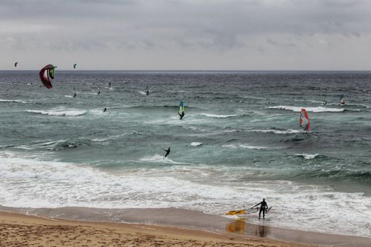 Surfers at Guincho beach under cloudy sky in spring Portugal