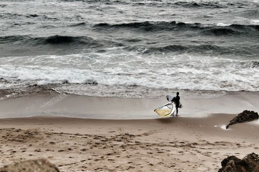 Surfers at Guincho beach under cloudy sky in spring Portugal