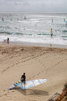 Surfers at Guincho beach under cloudy sky in spring Portugal