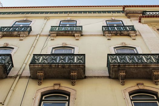Old colorful and majestic tiled facades with vintage streetlight in Lisbon streets in Spring.
