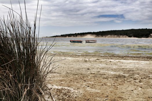 Boats on Lagoa de Albufeira on a cloudy day in Spring