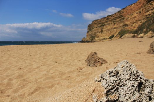 Crystal clear and wild waters in Praia da Foz, Sesimbra, Portugal. Golden sand , seagulls flying, Cliffs and rock formation