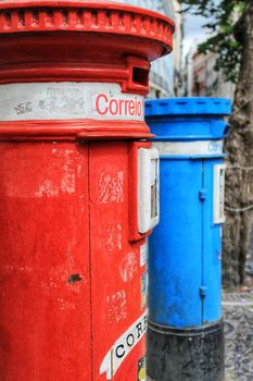 Colorful metallic vintage mail box in red and blue color on the street in Lisbon, Portugal. Word mail written on it.
