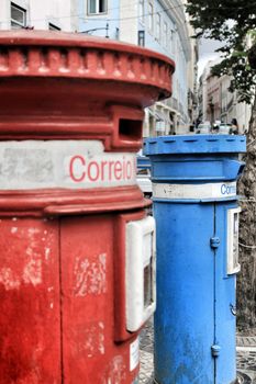 Colorful metallic vintage mail box in red and blue color on the street in Lisbon, Portugal. Word mail written on it.