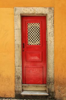 Old and colorful wooden door with iron details in Lisbon, Portugal