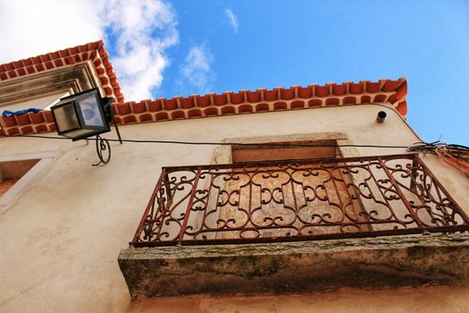 Old and colorful facade in Lisbon with plants and vintage lantern