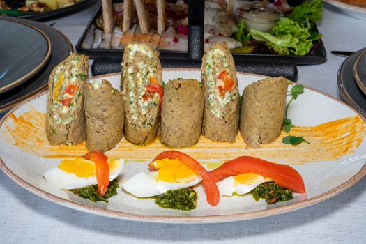 Cold appetizer of liver cake and eggs. Well served dish on a wooden table