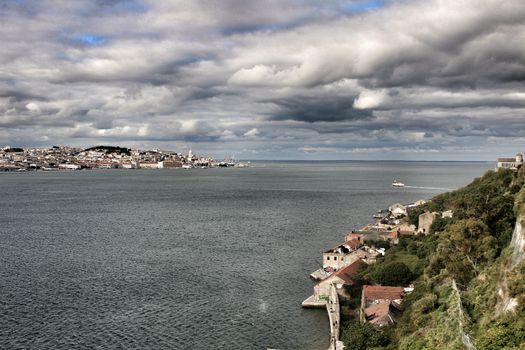 Panoramic of the docks of Cacilhas village and Tagus river on a cloudy day